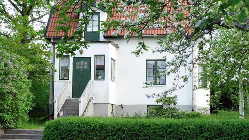 Hvid villa med fin grøn have